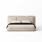 Kendric Bed straight-on front view with cream fabric frame, white bedding, and black throw