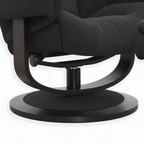 Close-up of the black curved support leg, pivot hardware, lower frame, and round base on the Trevoux accent chair.