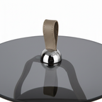 Close-up of the black tempered-glass tabletop, chrome connector, and leather loop on the Lorisse End Table